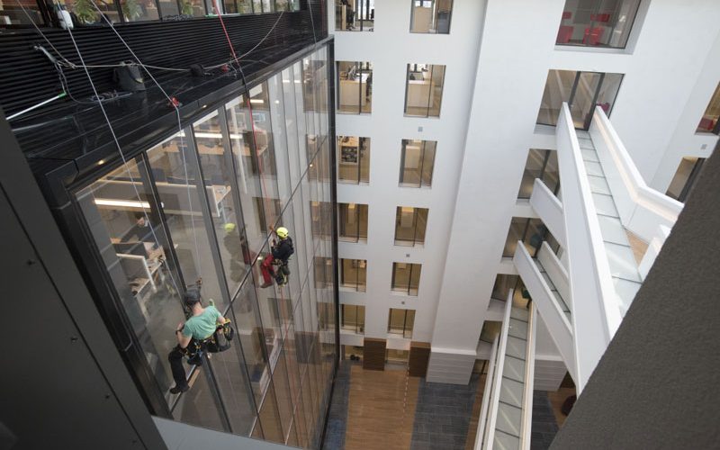 Nettoyage sur corde de vitres à l'intérieur d'un bâtiment